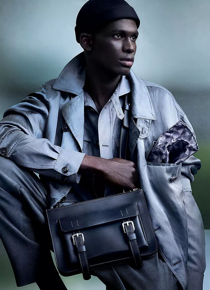 Man with Louis Vuitton Brown Backpack before Giorgio Armani