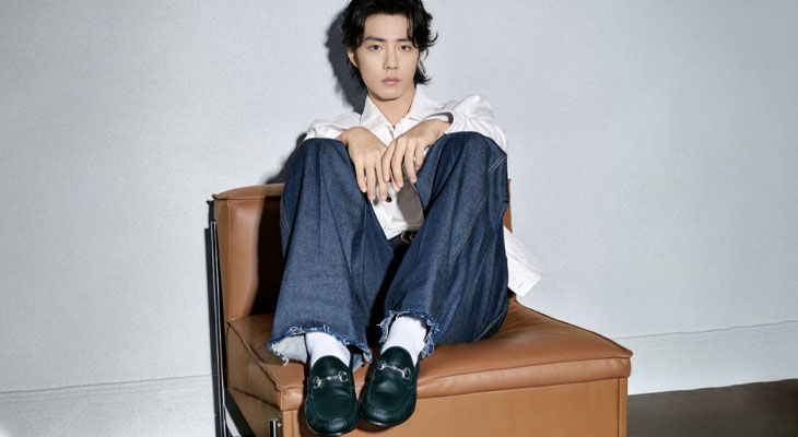 BTS Singer Jin Is Sitting In White Wall Background Wearing Blue